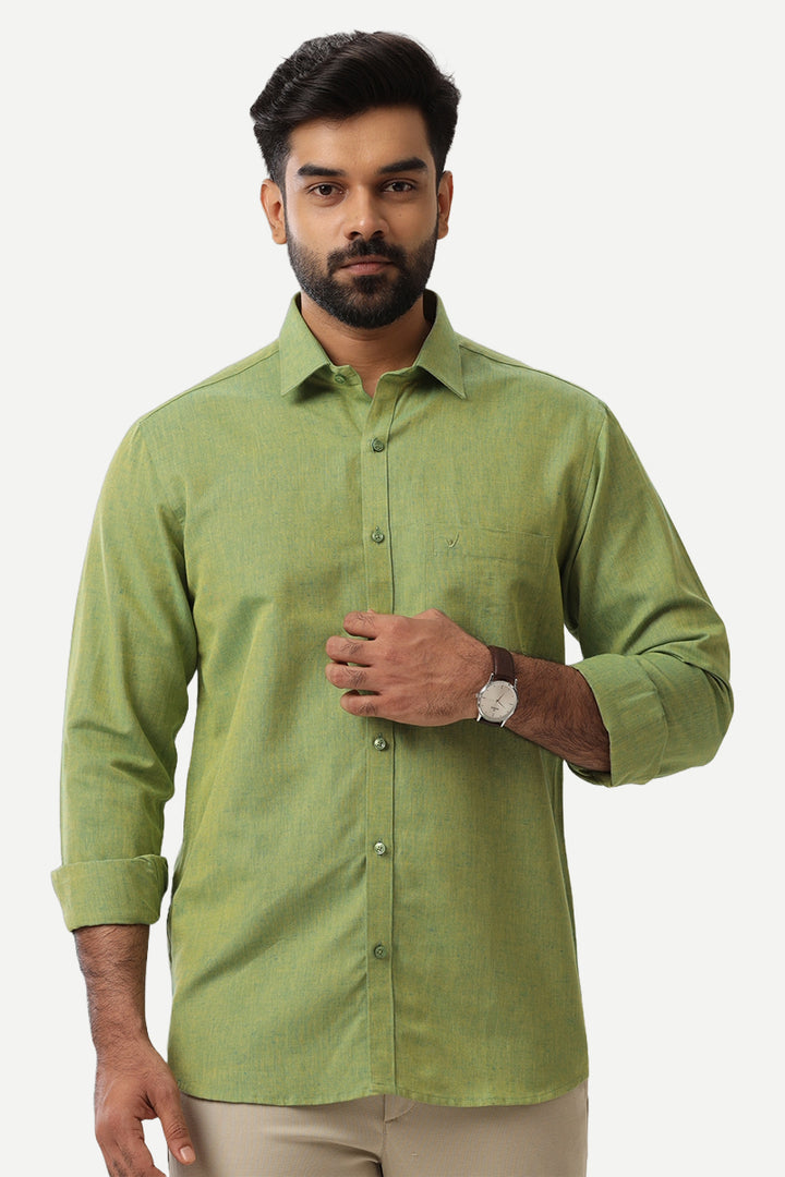 A man wearing a light green, solid-pattern, formal shirt with an arrow cut at the bottom.