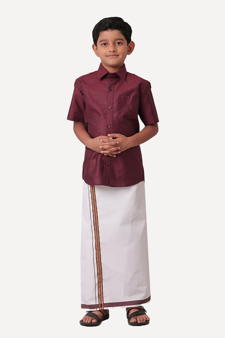 A kid in a maroon shirt and white dhoti set