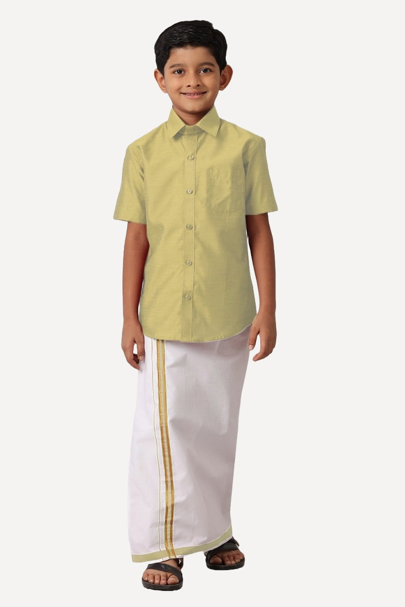 A boy wearing a tan shirt with half sleeves and matching dhoti