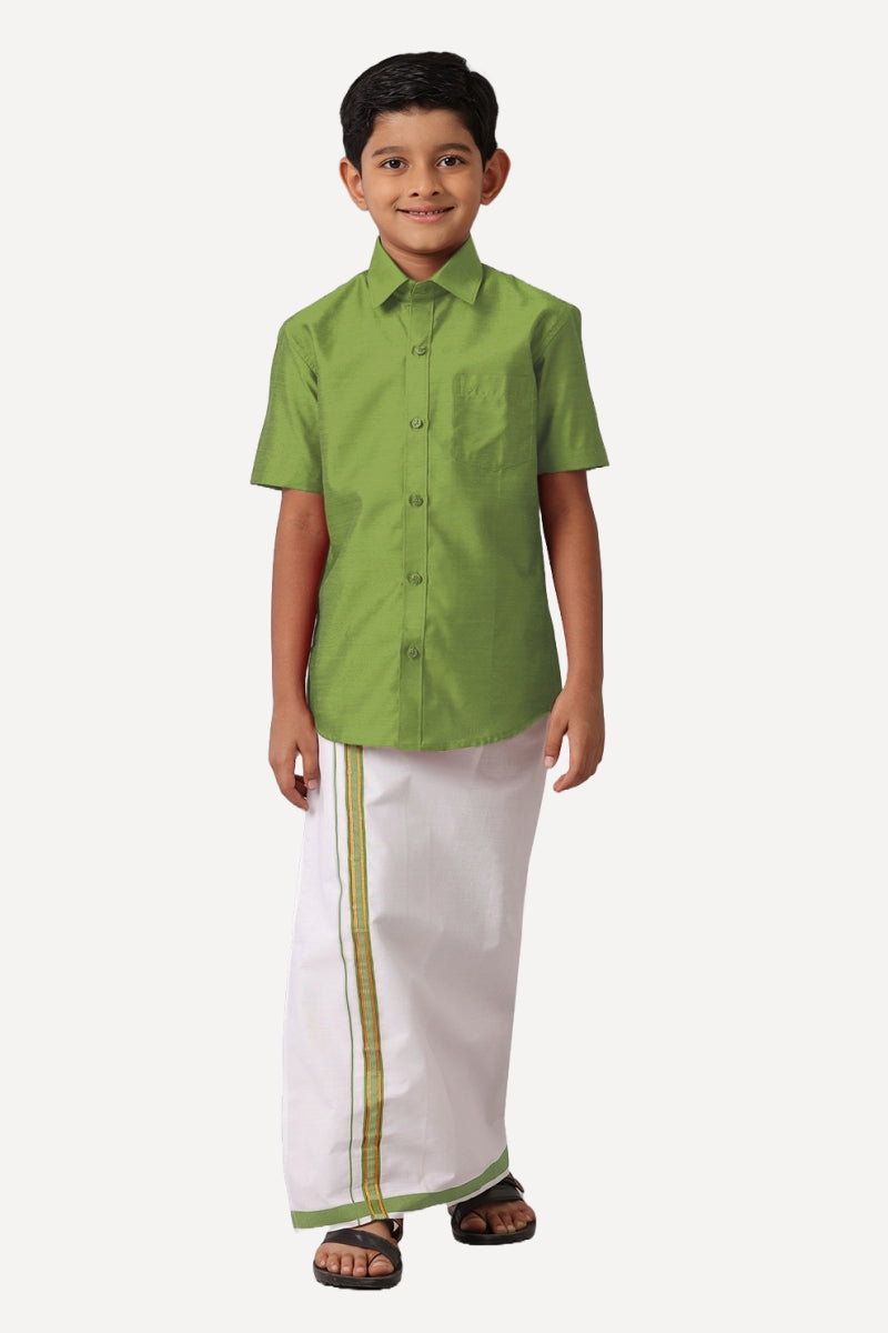 A boy wearing a leaf green shirt with half sleeves and matching dhoti.