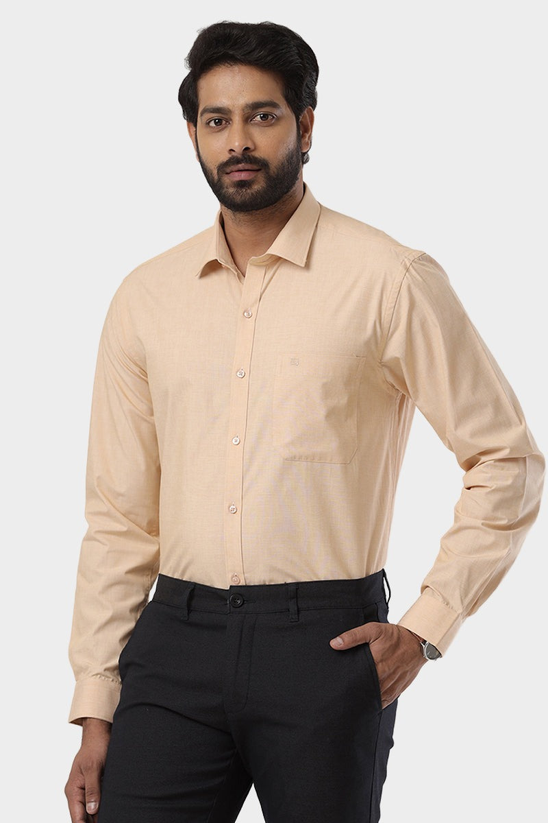 A man wearing a beige long-sleeved formal shirt with a collar, and a solid pattern.
