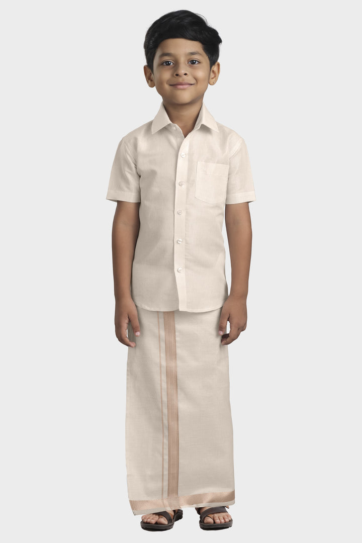 A boy wearing an almond tissue shirt and dhoti set with a solid pattern.