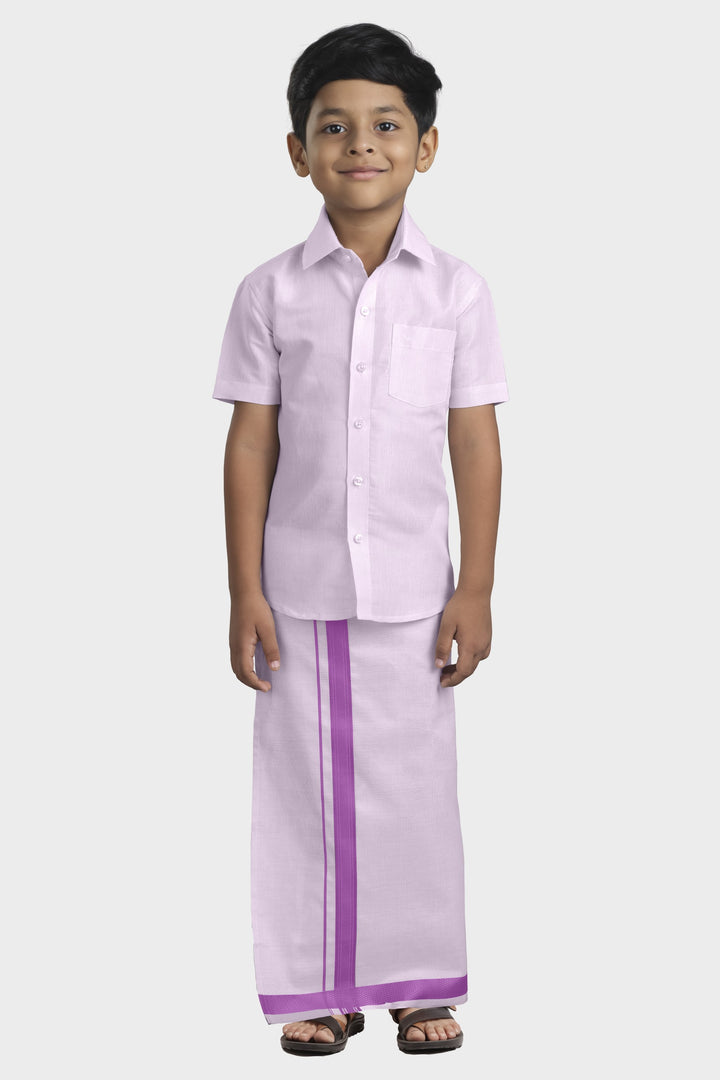 A child wearing a purple tissue shirt and dhoti set.