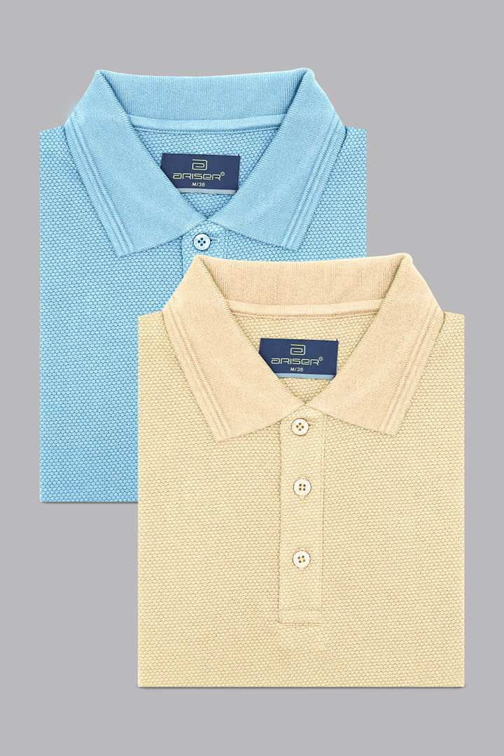 Two folded polo shirts, one blue and one beige, on a gray background.