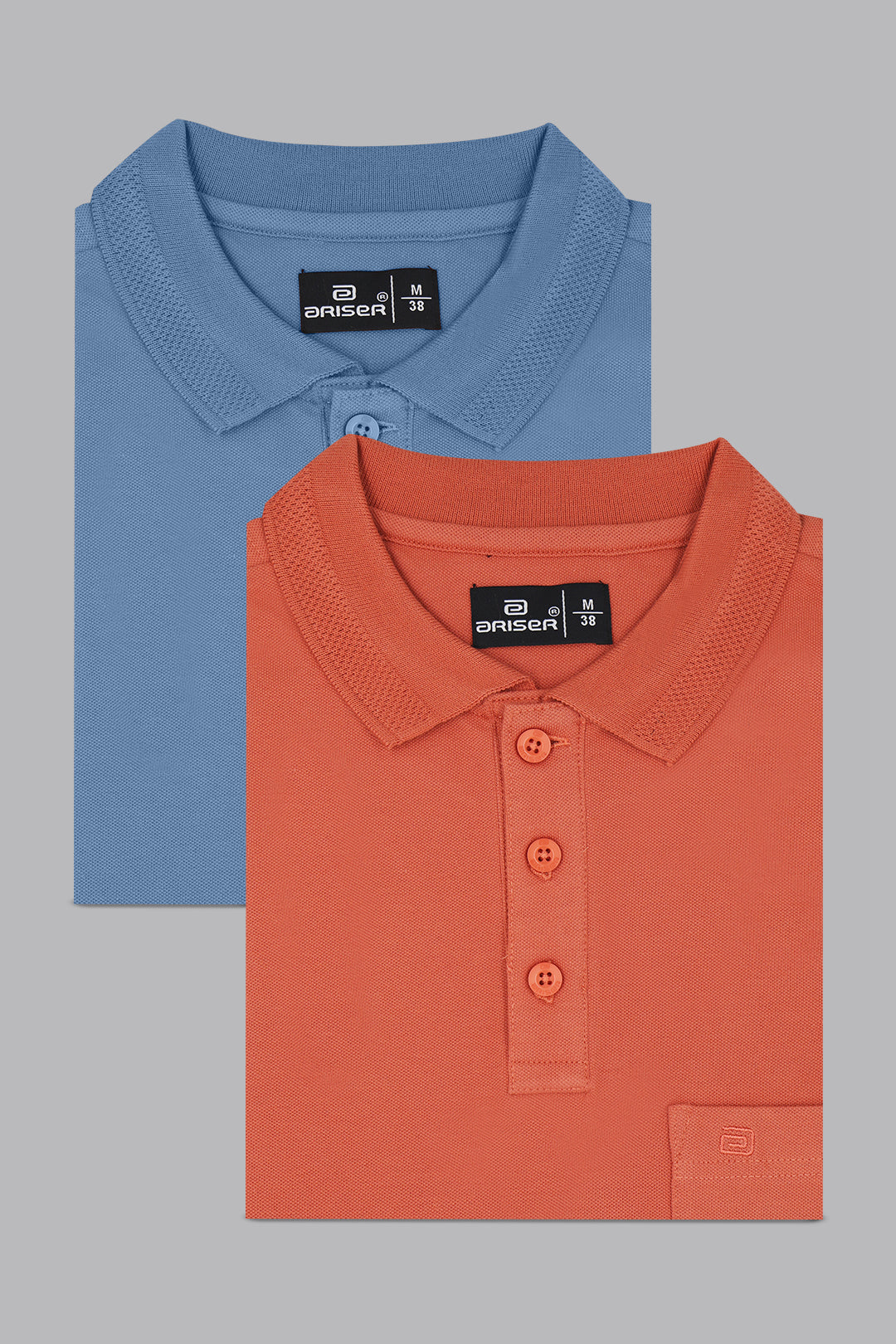 Two folded polo shirts, one blue and one orange, on a gray background.