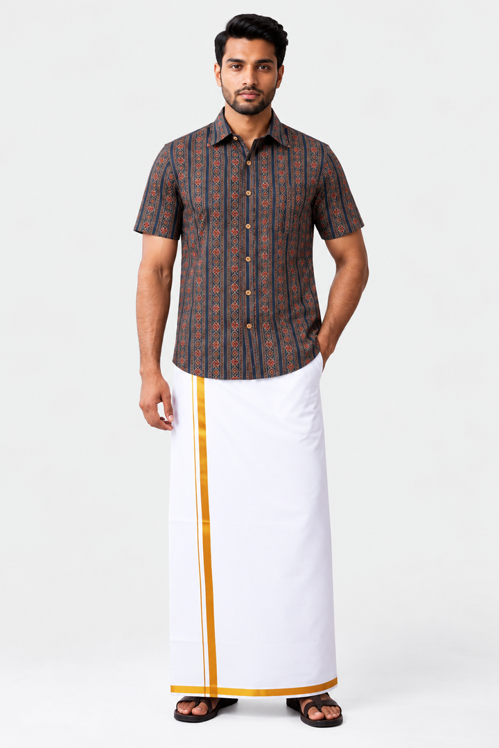 A man modeling a traditional outfit consisting of a short-sleeve button-up shirt with a dark brown and orange vertical pattern, paired with a white drape (kurtu) featuring a gold border, on a light gray background.