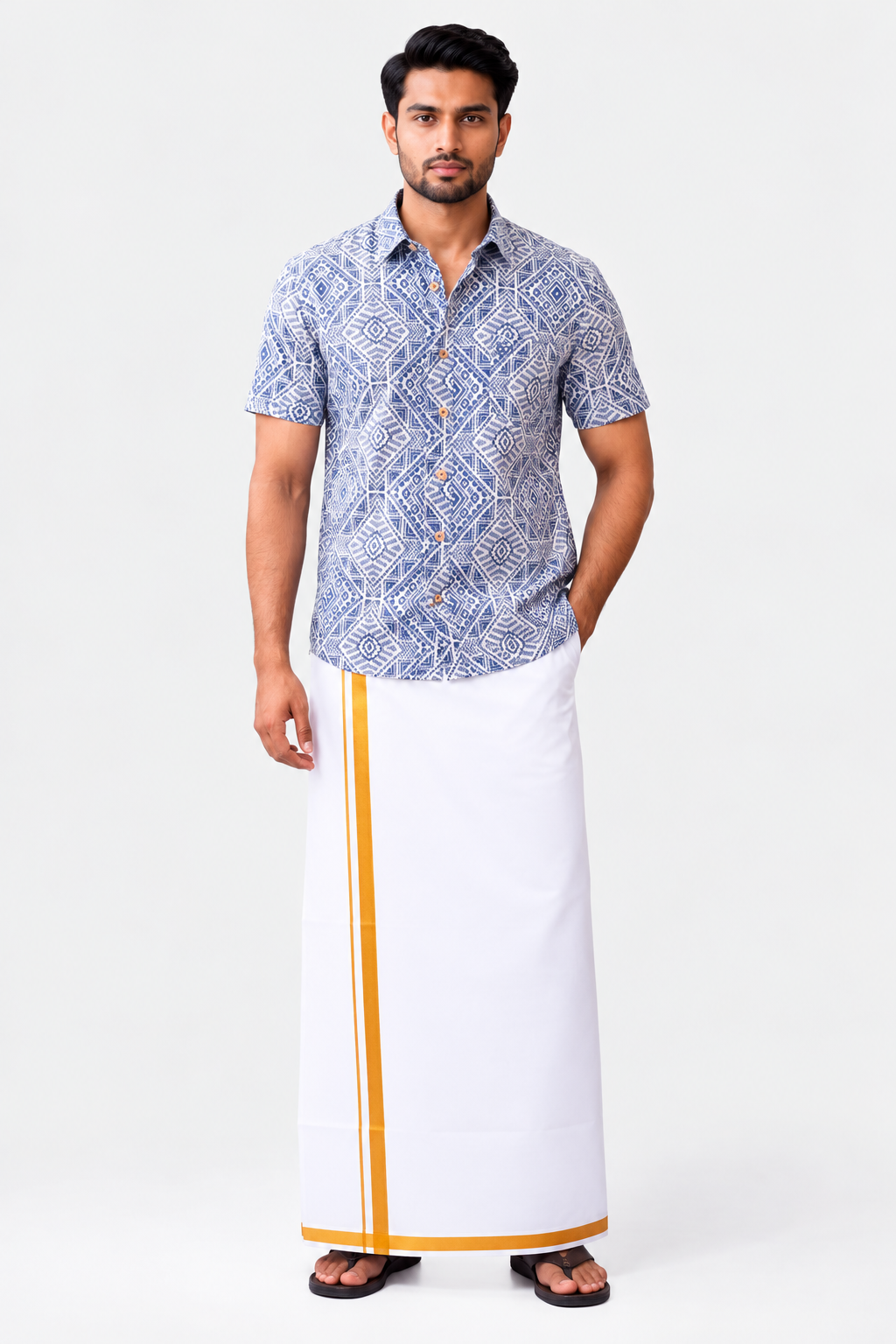 A man modeling a short-sleeve button-up shirt with a blue and white geometric pattern, paired with a white traditional wrap skirt featuring a yellow stripe, on a light gray studio background.
