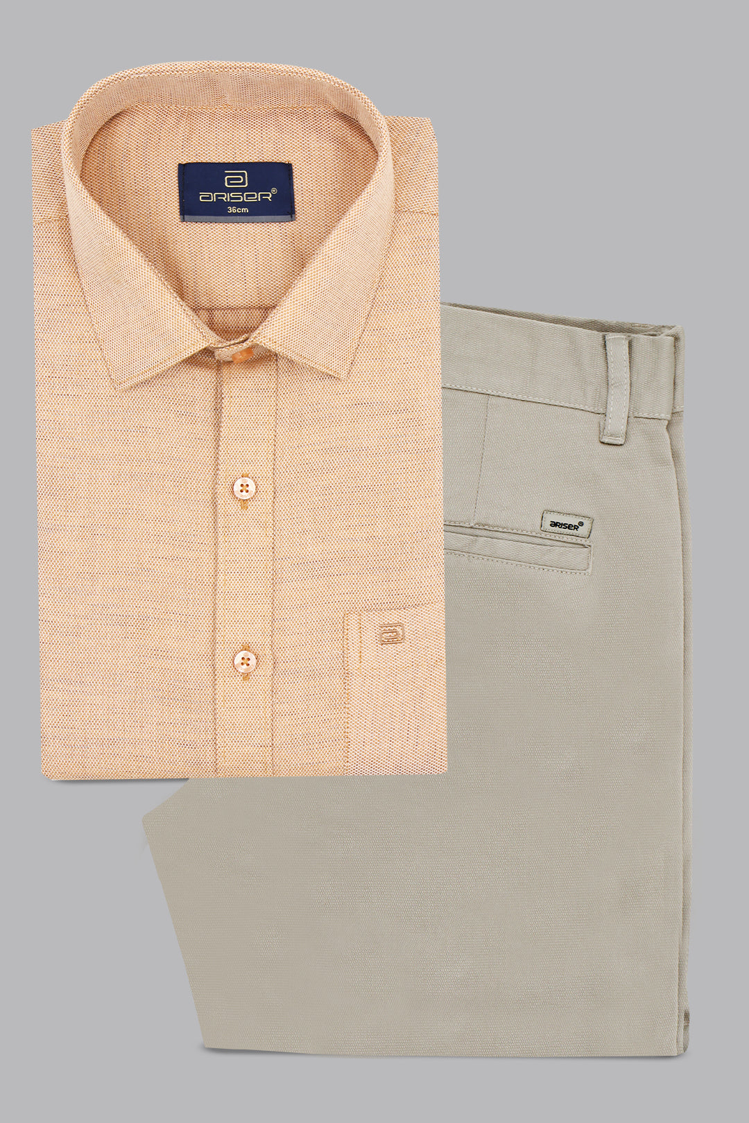 Folded beige shirt and khaki pants with a visible brand label on a gray background