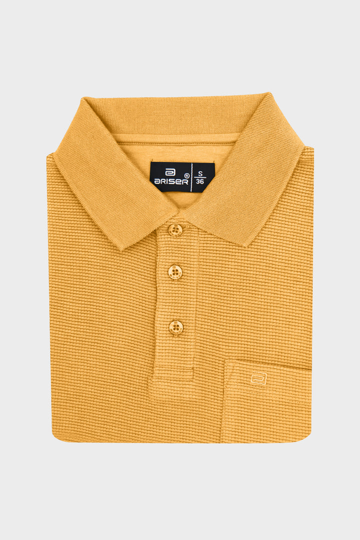 A folded mustard-yellow ribbed-knit polo T- shirt with a collar, three-button placket, and a chest pocket, shown on a light gray background. The brand label reads 'Ariser'.