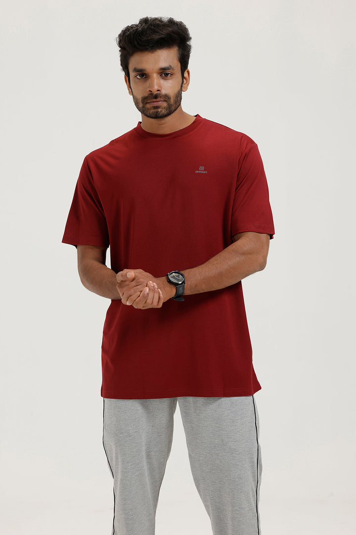 Man wearing a red t-shirt and gray pants on a white background