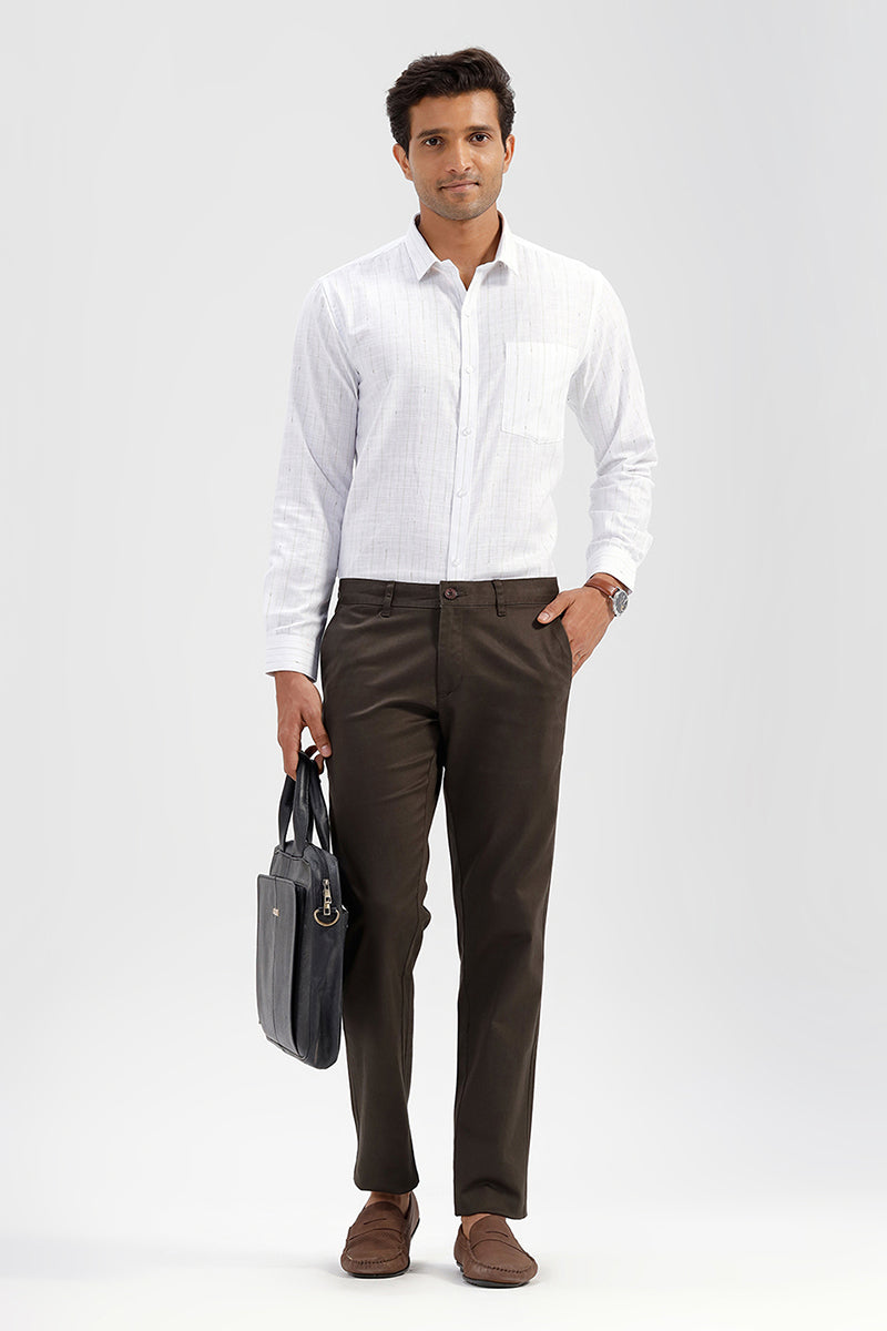 Man wearing a white shirt and brown pants holding a black briefcase on a light gray background