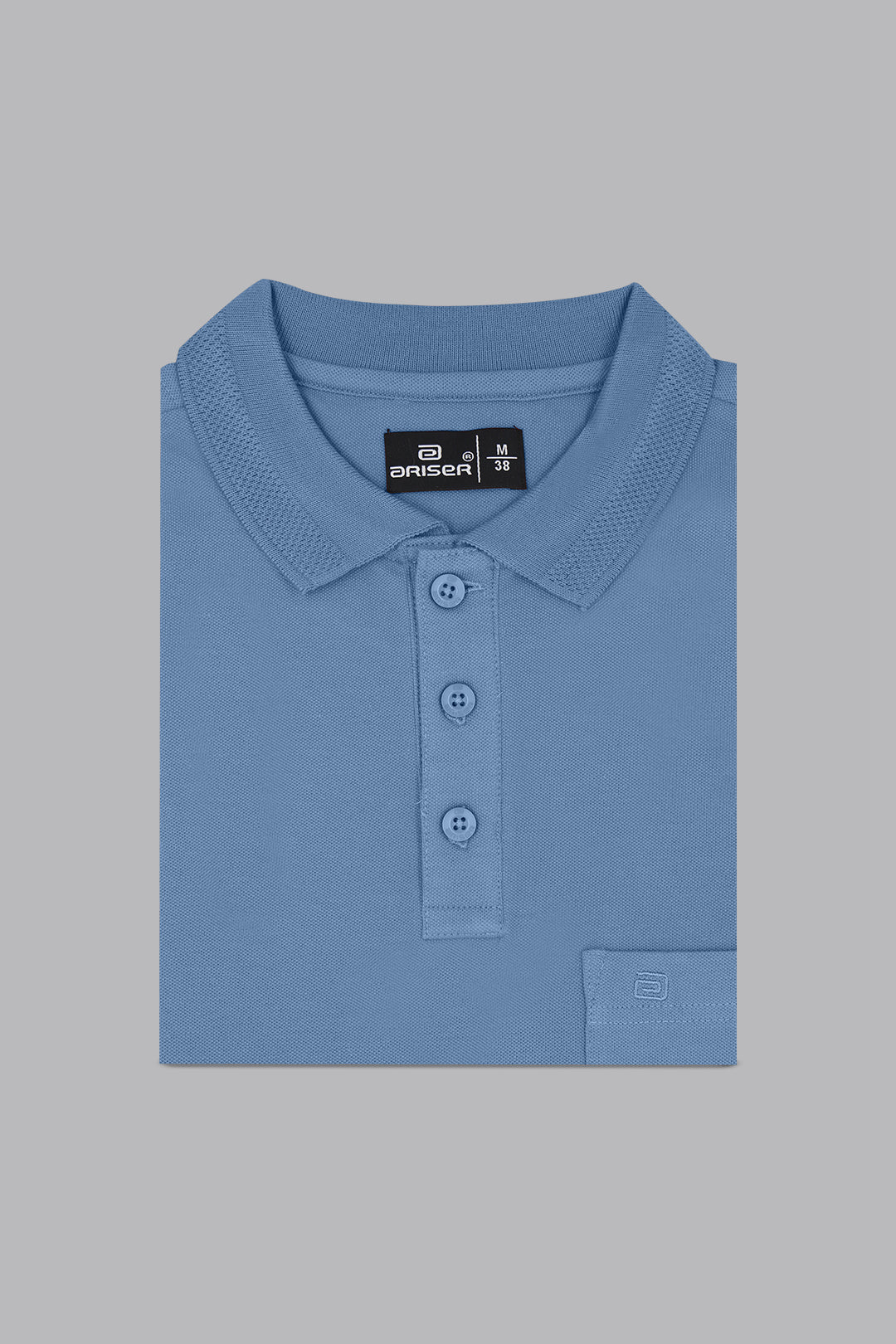 Folded blue polo shirt with a brand label on a gray background