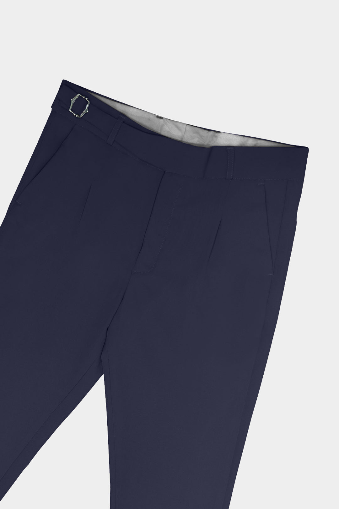 Close-up of navy blue trousers showing the waistband, belt loops, front creases, and side pocket on a light gray background.
