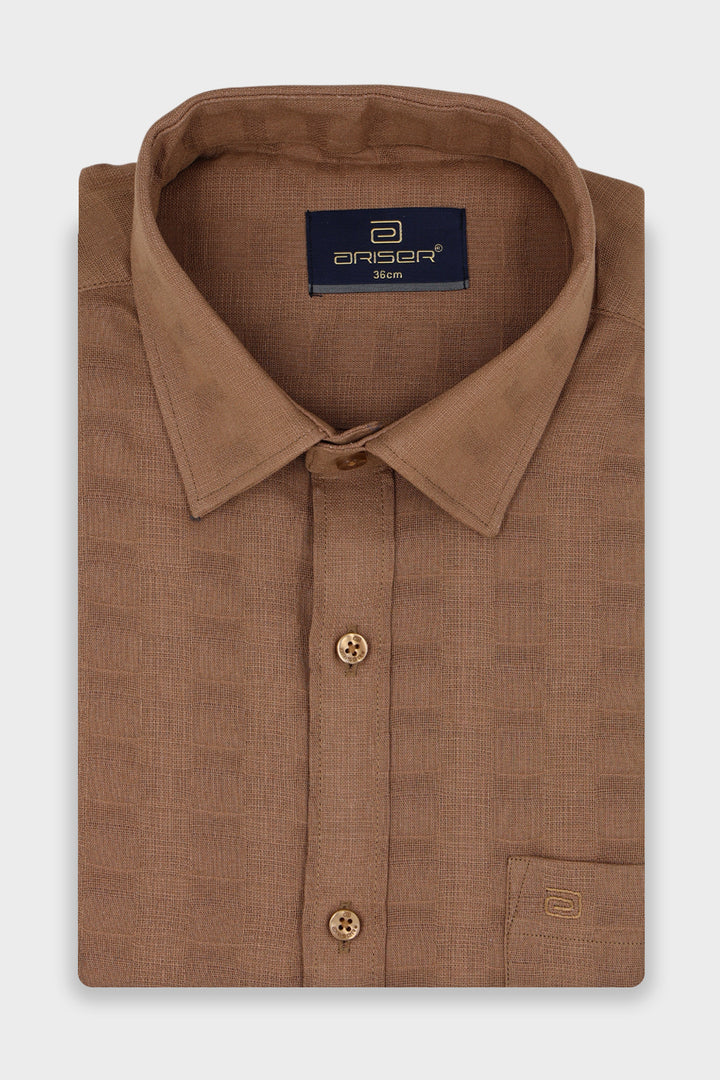 A folded brown long-sleeve dress shirt with a textured weave, featuring a pointed collar, button-down front, and a brand label on the inner neck.