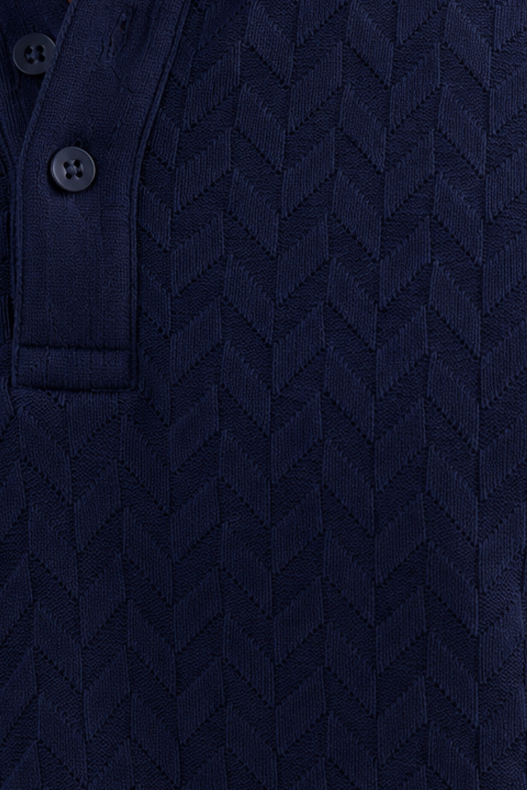 Close-up of a dark navy blue textured knit polo shirt showing a buttoned collar and a chevron pattern.