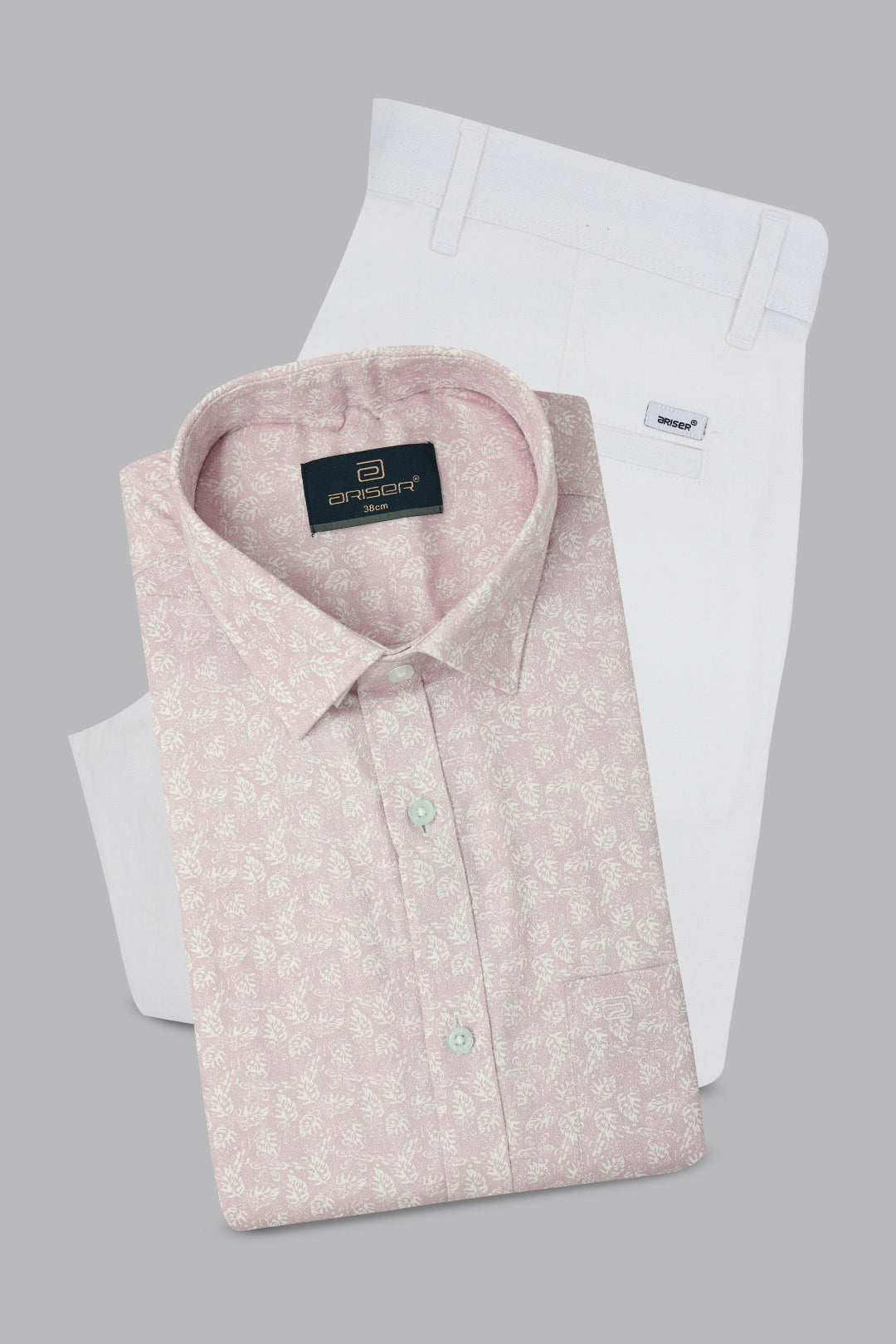 Pink patterned shirt and white pants with brand labels on a gray background