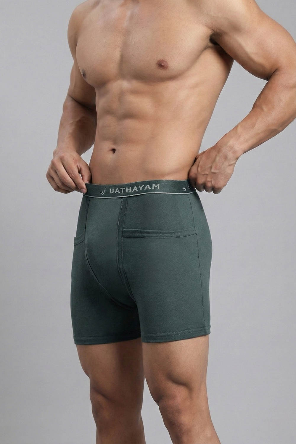 Man wearing green underwear with 'Uathayam' branding on a gray background
