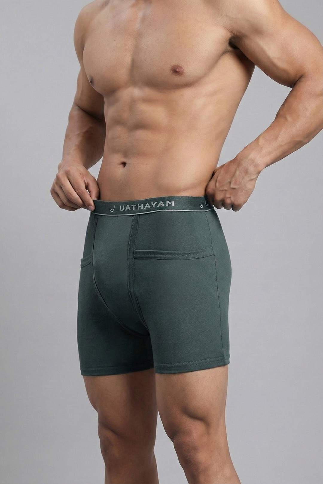 Man wearing green underwear with 'Uathayam' branding on a gray background