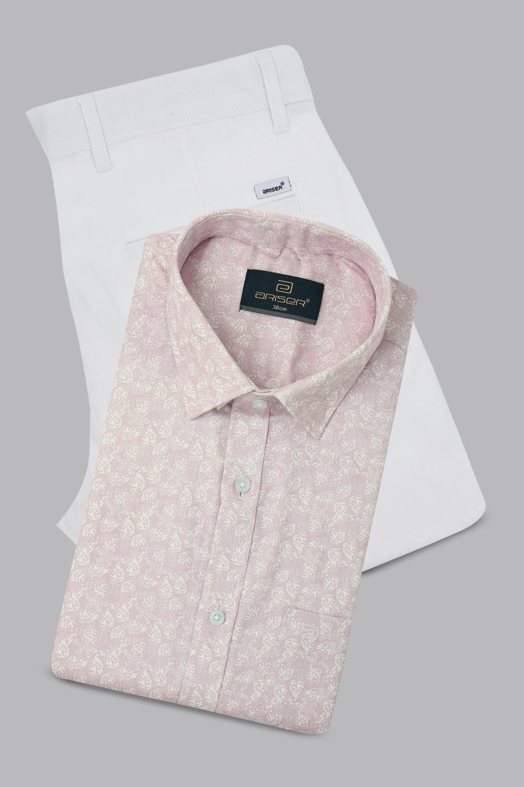 Folded pink shirt with a ariser label on a white background
