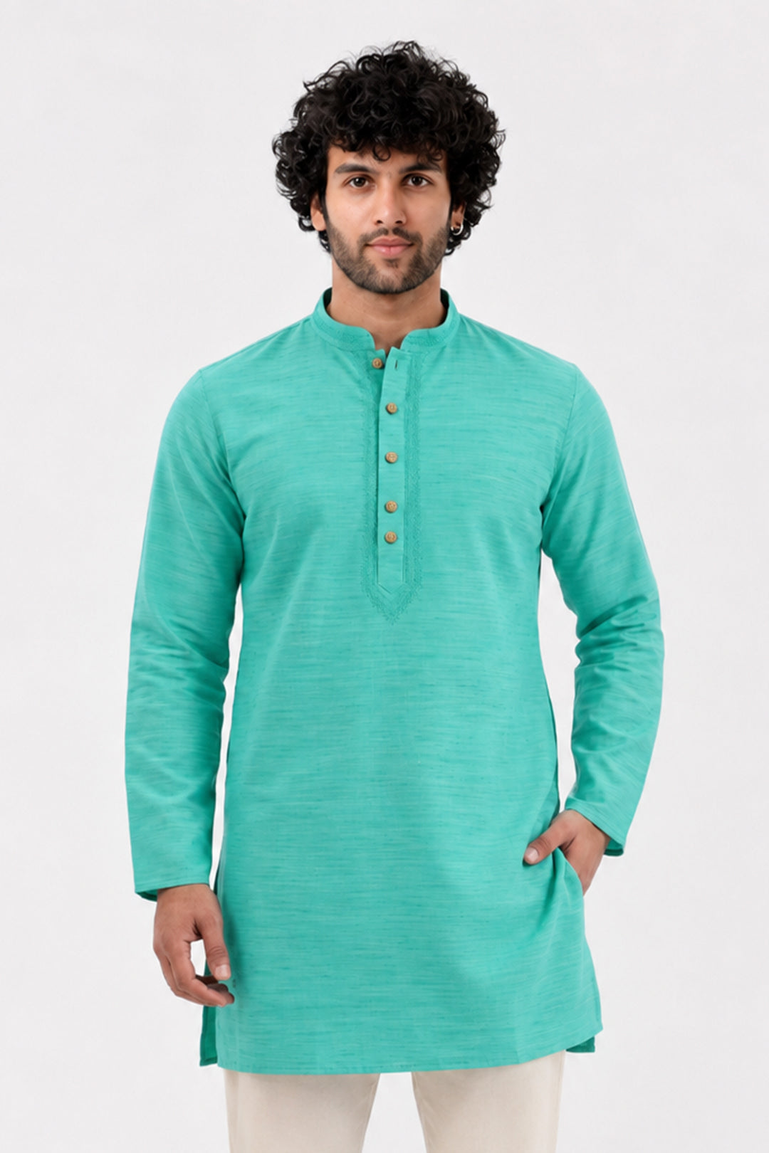 A man wearing a green long-sleeve kurta with a buttoned mandarin collar, paired with off-white trousers, standing against a light gray studio background.