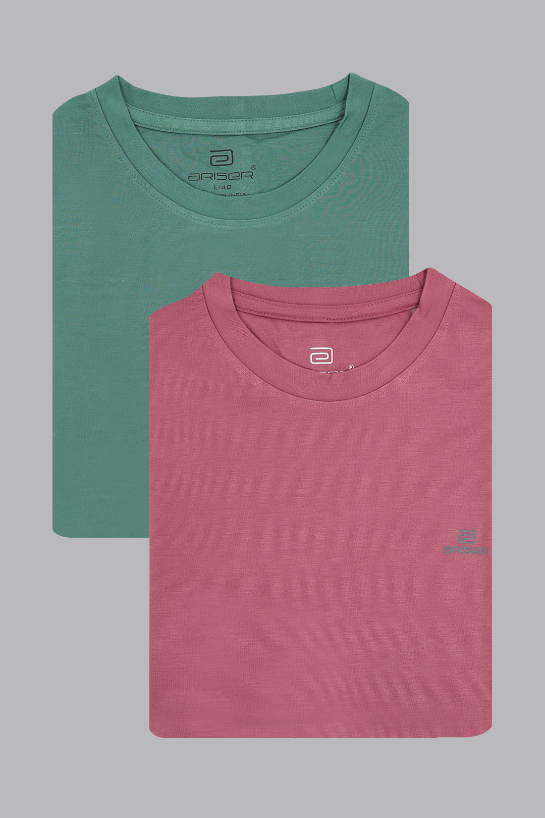 Two folded t-shirts, one green and one pink, on a gray background.