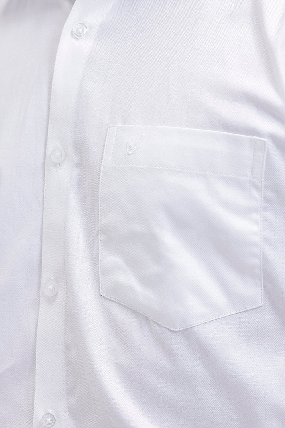 Close-up of a white long-sleeve button-down shirt showing the chest pocket, button placket, and fine fabric texture.