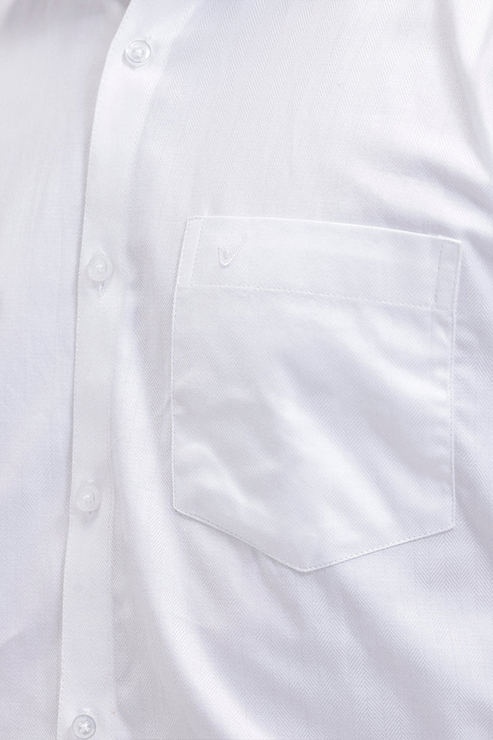 Close-up of a white long-sleeve button-down shirt showing the chest pocket, button placket, and fine fabric texture.