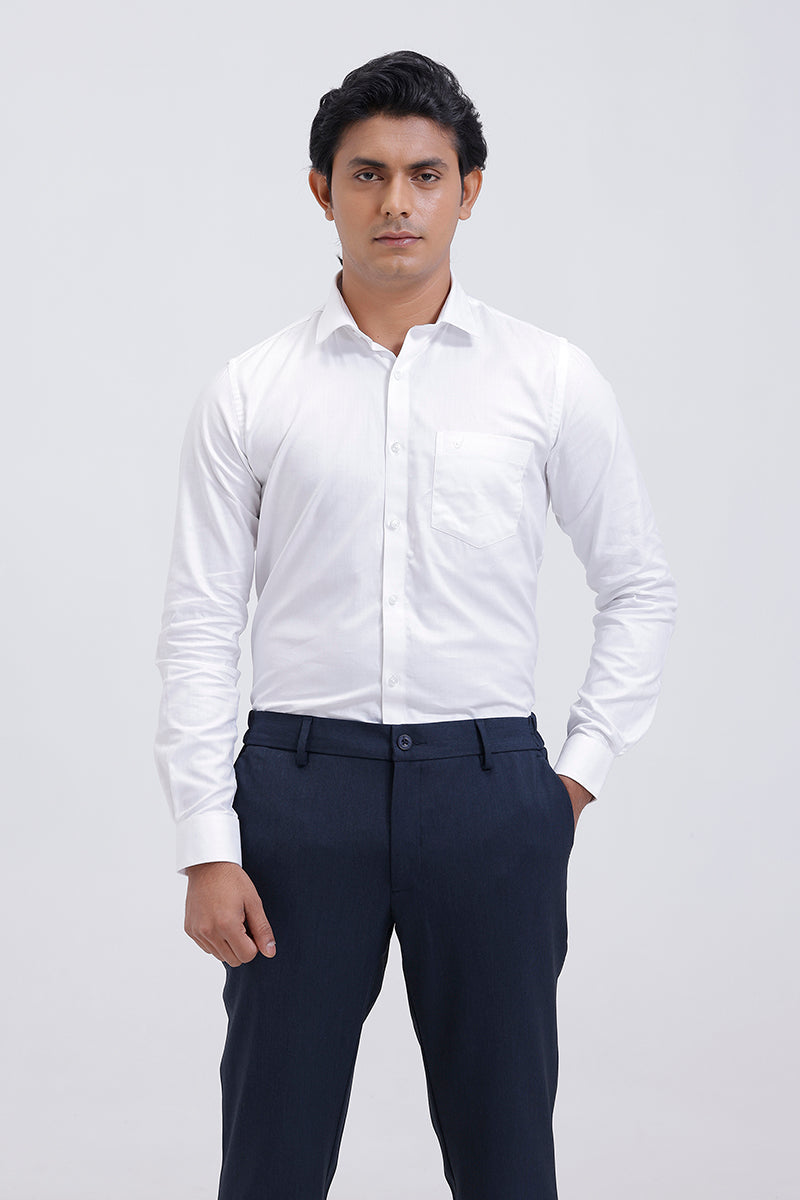 Man wearing a white dress shirt and dark pants on a light gray background