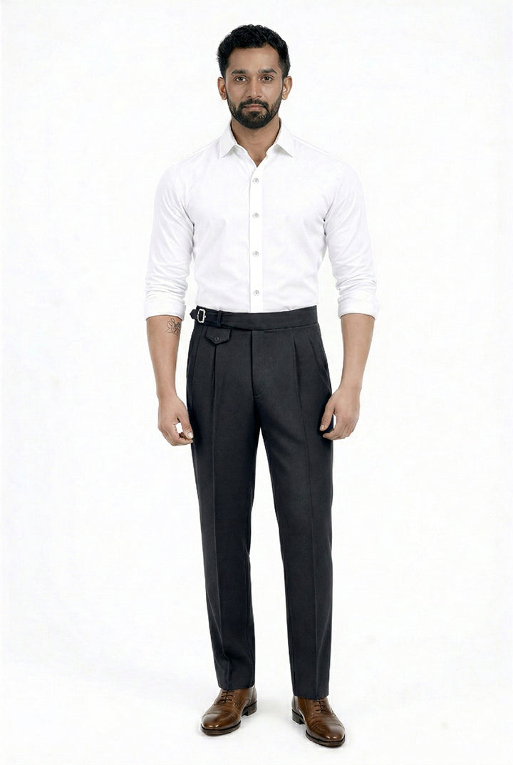 Man wearing a white shirt and dark trousers on a white background