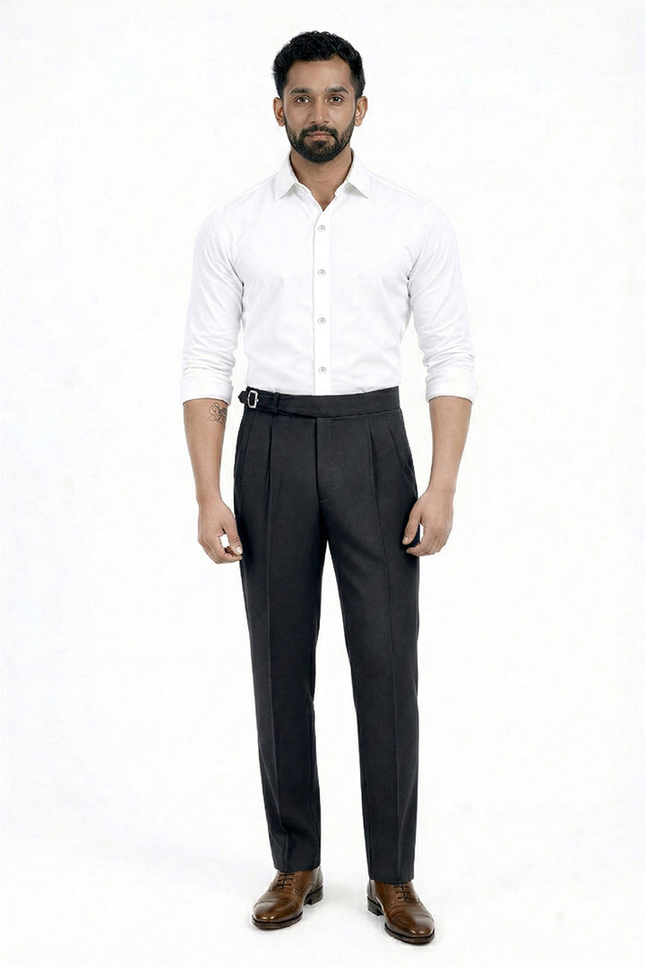 Man wearing a white shirt and dark trousers on a white background
