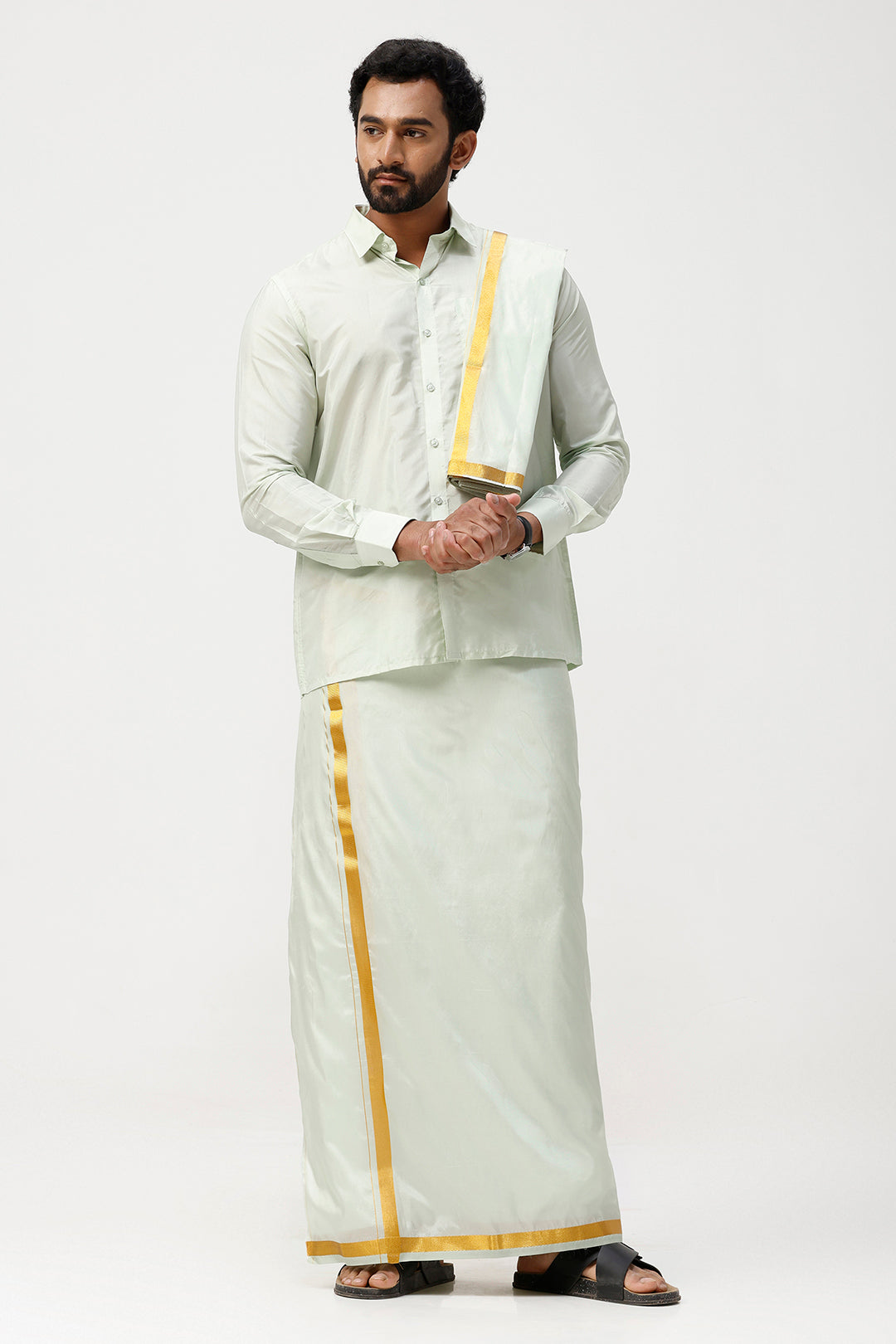 Man wearing a traditional white outfit with gold accents on a white background