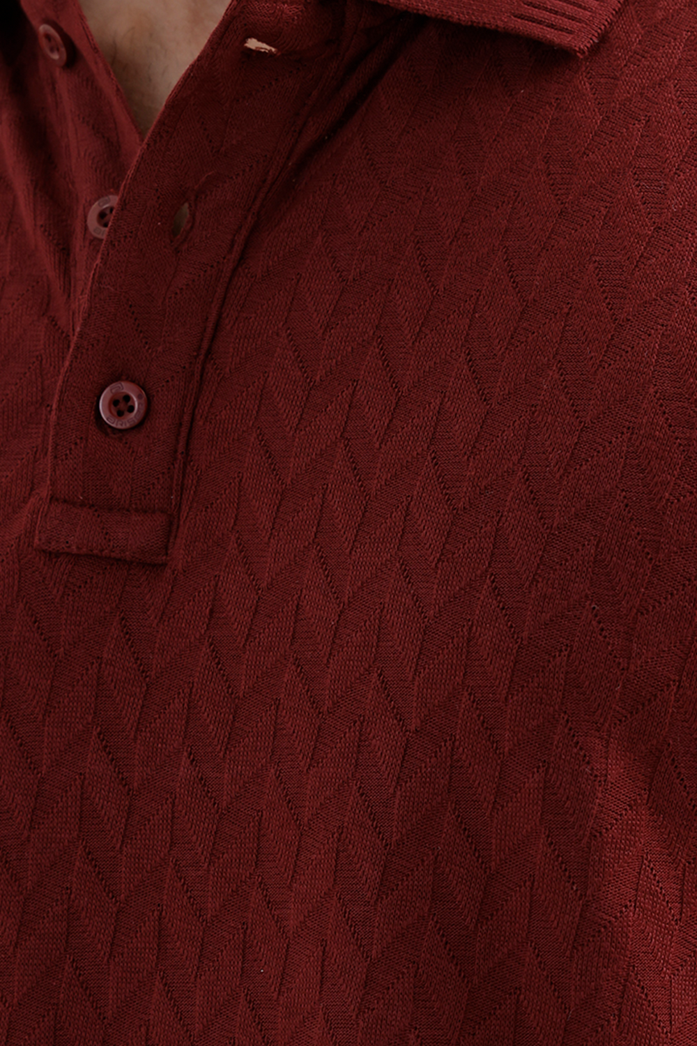 Close-up of a textured polo shirt in a deep maroon, showing the diamond-patterned knit fabric and matching buttons.