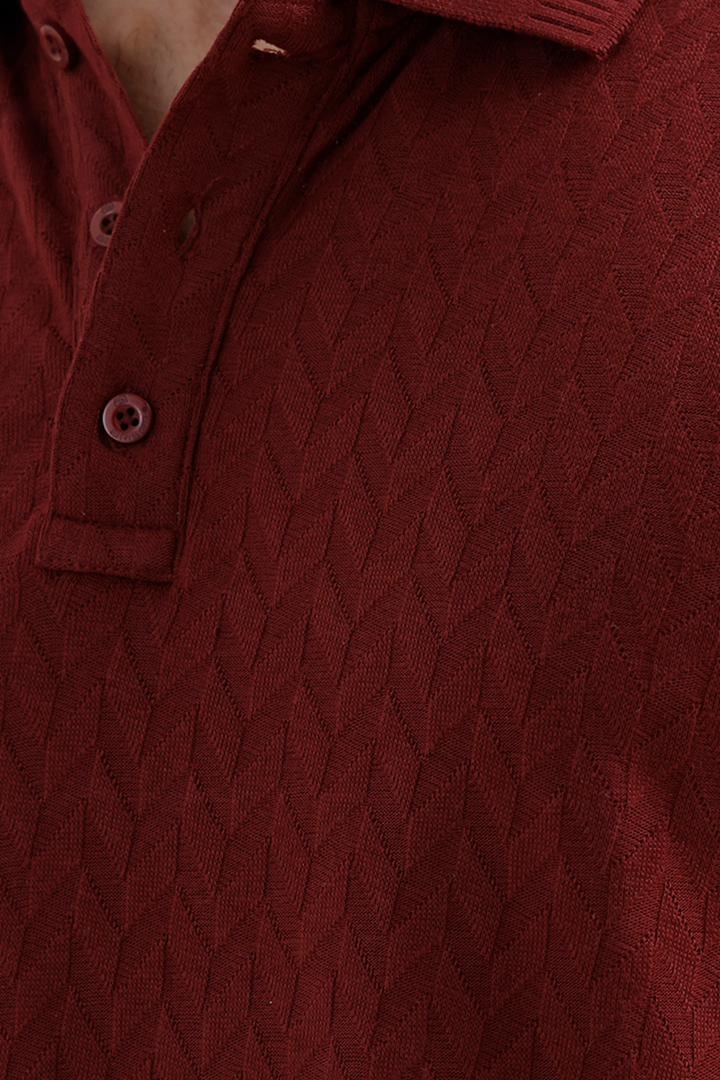 Close-up of a textured polo shirt in a deep maroon, showing the diamond-patterned knit fabric and matching buttons.