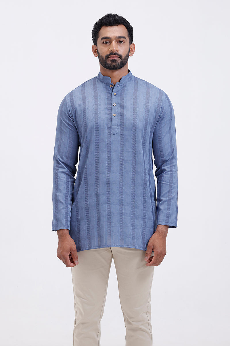Man wearing a slate blue striped kurta with beige pants on a white background