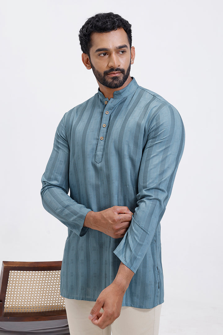 Man wearing a blue striped kurta against a white background