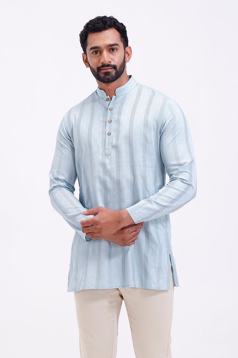 Man wearing a ice blue kurta with white stripes on a white background