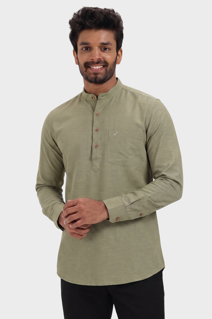 A man wearing a light olive green long-sleeve kurta with a mandarin collar and three-quarter button placket, paired with black trousers, against a solid light gray background.