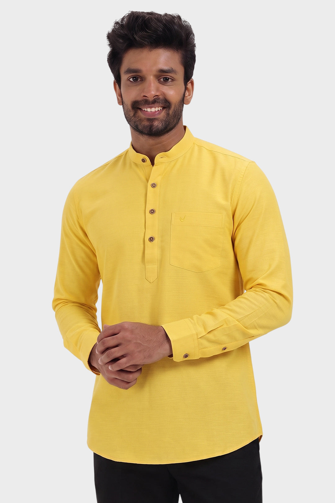 A man wearing a bright yellow long-sleeve kurta with a mandarin collar and a three-button placket, paired with black trousers, against a light gray background.