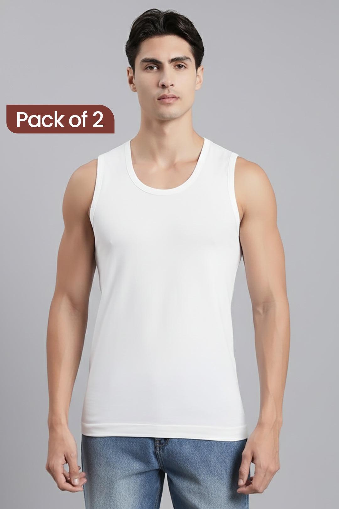 A man modeling a white sleeveless tank top against a light gray studio background, with a brown label in the upper left that reads 'Pack of 2'.