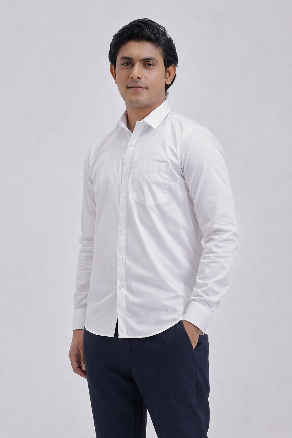 Man wearing a white dress shirt and dark pants on a light gray background